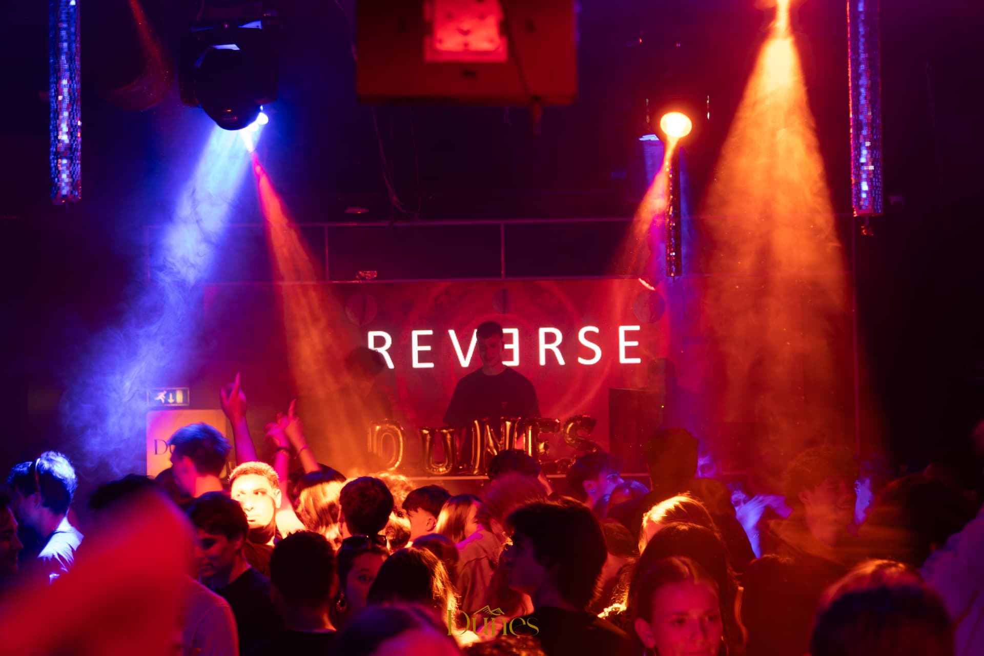 Crowd at a Dunes event under red and blue stage lights with the Reverse and Dunes branding