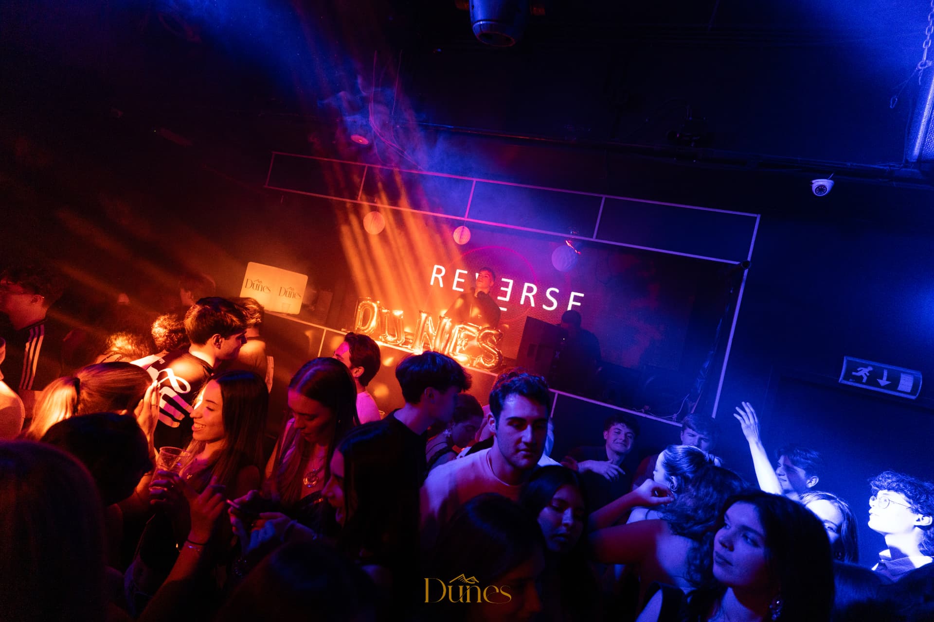 Crowd under blue and orange light at a Dunes club night